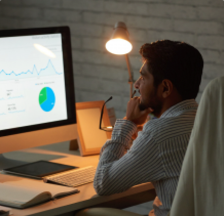 Analyst monitoring risk dashboards at night
